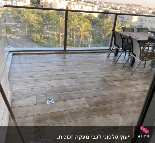 מעקה זכוכית במרפסת עם נוף לעיר